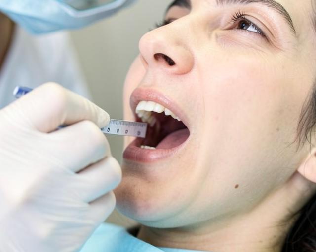 Dentista medindo a abertura da boca de uma paciente